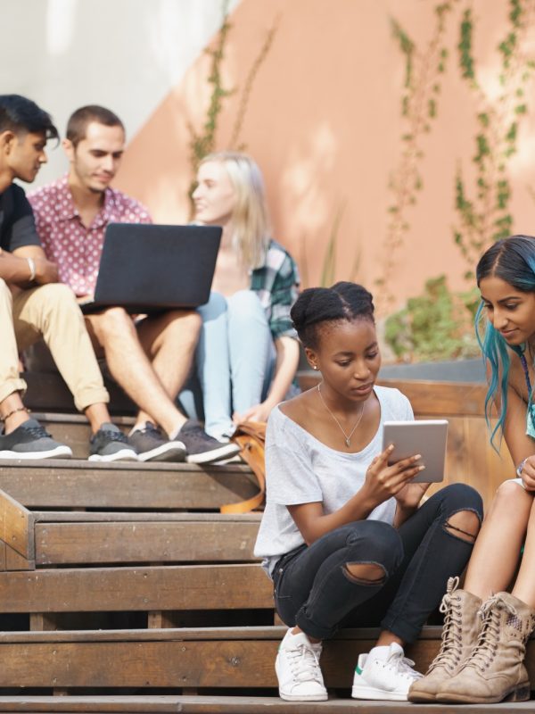 The students stairs. Shot of a group of young students enjoying a break outdoors on campus.